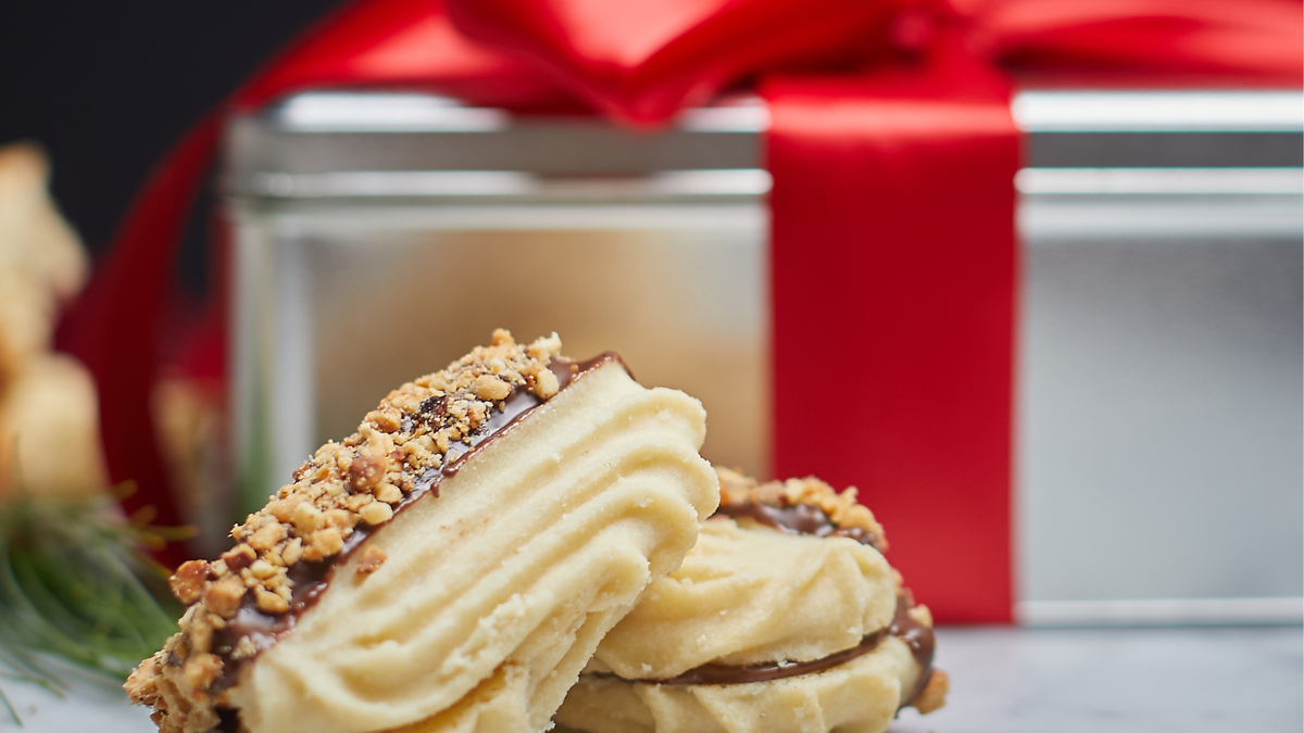 Giorgio signature biscotti jar with a black lid beside a cookie jar with a brushed nickel lid on a marble counter